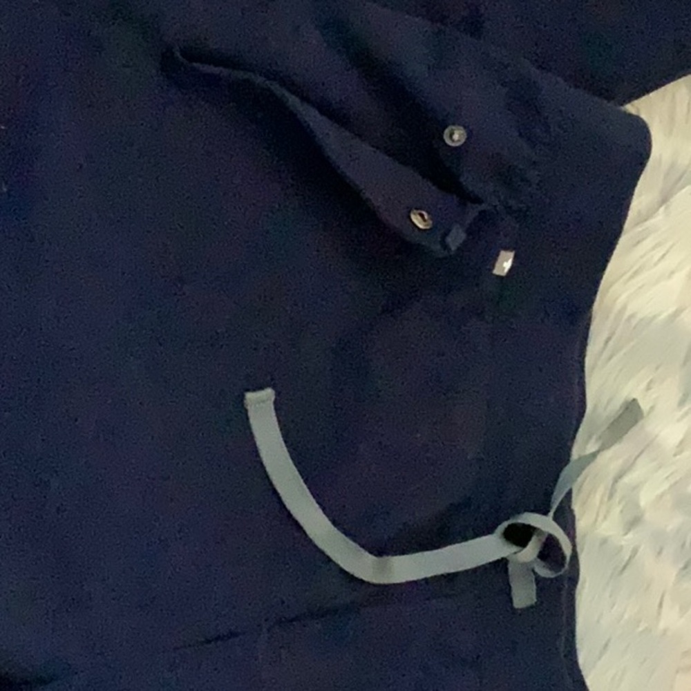 Figs navy blue scrub pants in large .pocket on the side has a snap.